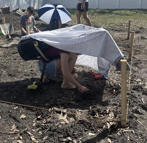 Prototype 2 in action at the dig site — PVC frame with shower curtain covering the digger